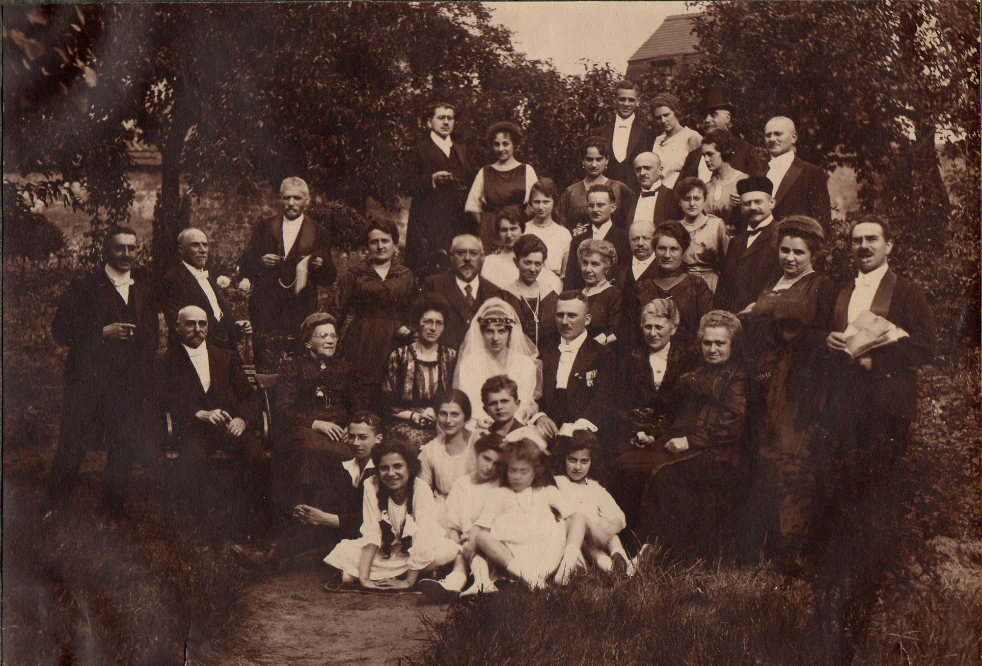 Schwarz-Weiß-Gruppenfoto mit Brautpaar und Familie, circa 30 Personen