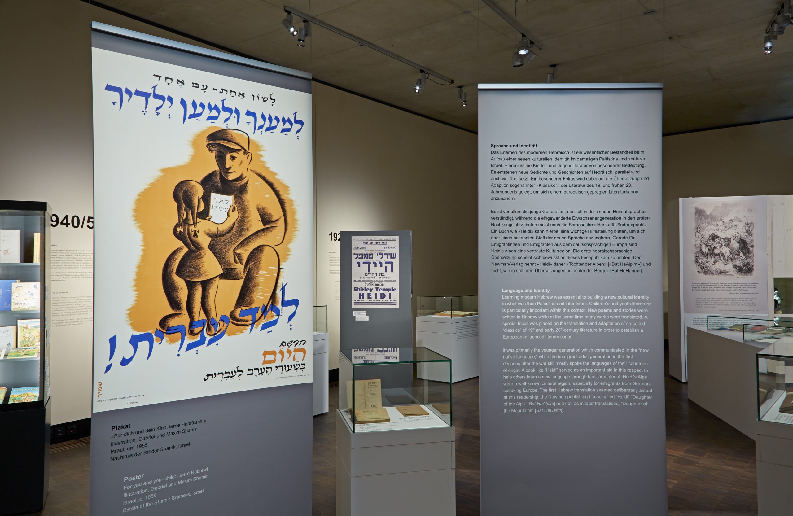 Roll-Ups in der Ausstellung mit einem hebräischsprachigen Plakat und Text zum Thema "Sprache und Identität"