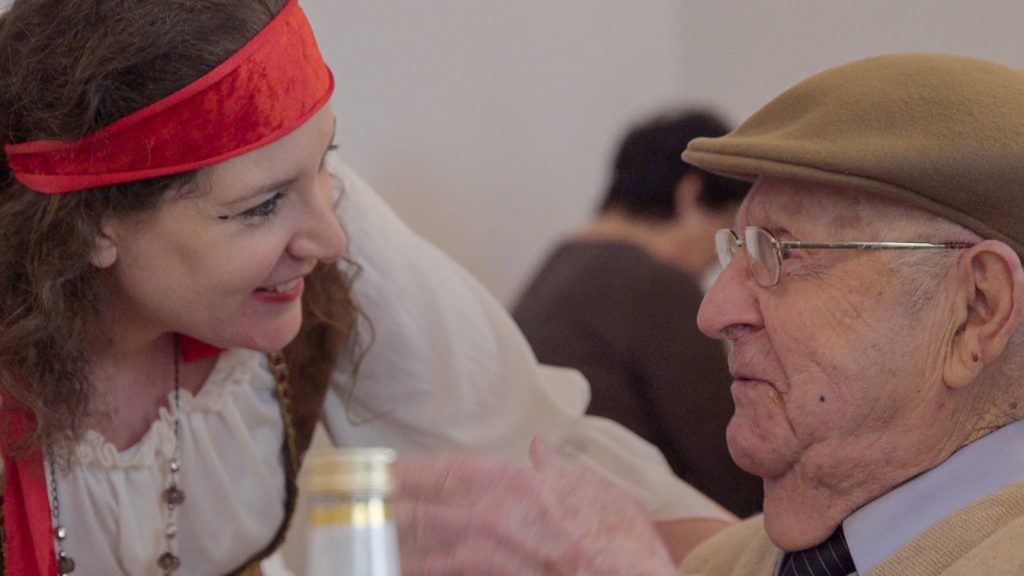 Miriam Arco-Pres als Piratin verkleidet beugt sich runter zu dem sitzenden Henry Rotmensch. Er ist nicht verkleidet und schaut ernst