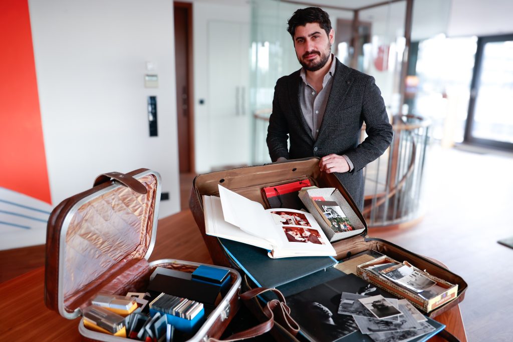 Roy Rajber steht neben einem Koffer voller Fotoalben und anderen Erinnerungsstücken